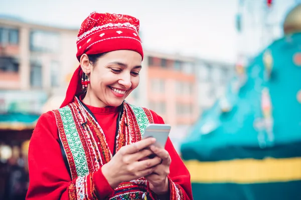 7000 BDT App — Enjoy seamless gaming on your smartphone A young woman relaxing with her phone while dynamic casino elements float around her, illustrating the smooth mobile experience offered by the 7000 BDT app.